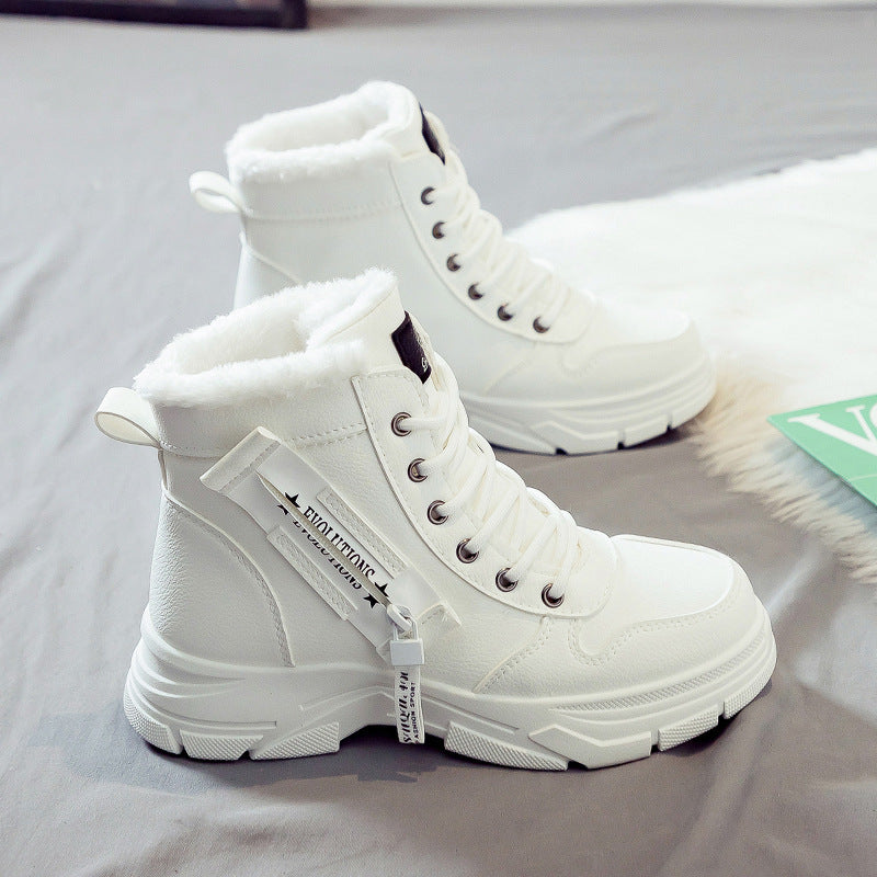 Weiße Damen-Winterstiefel mit Kunstfellfutter, seitlichem Reißverschluss und Schnürung auf grauem Hintergrund. Modische, warme Winterschuhe.