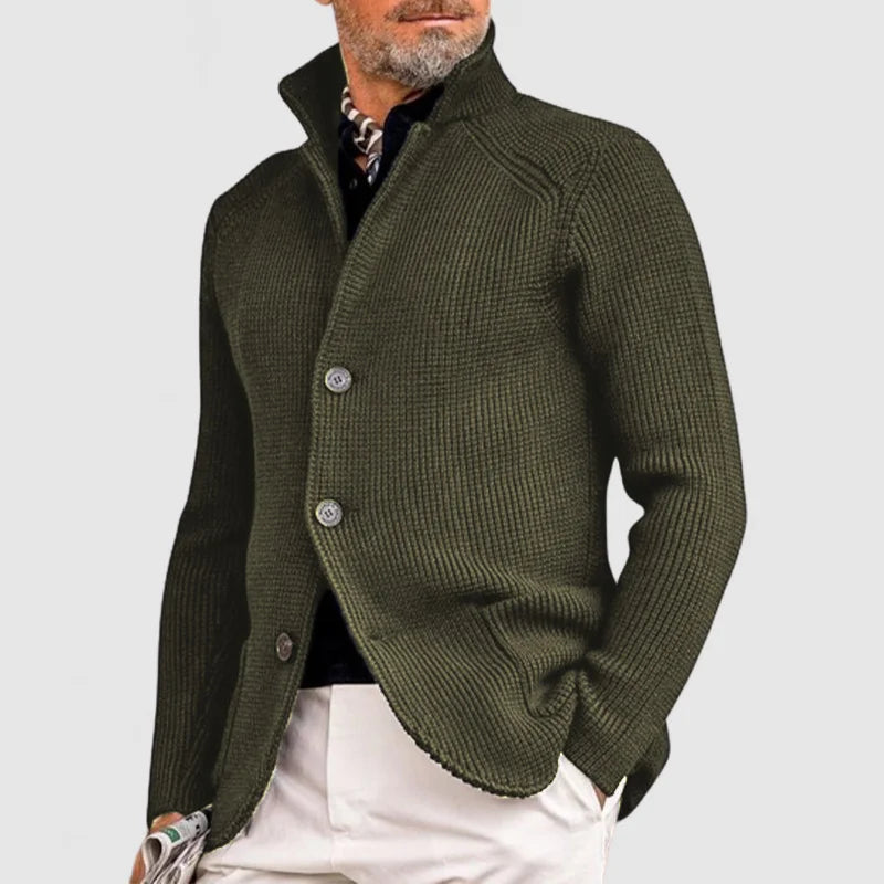 Grüner Herrenstrickjacke mit Stehkragen und Knöpfen, kombiniert mit weißer Hose. Elegante Herbstmode für Männer, stilvoll und modern.
