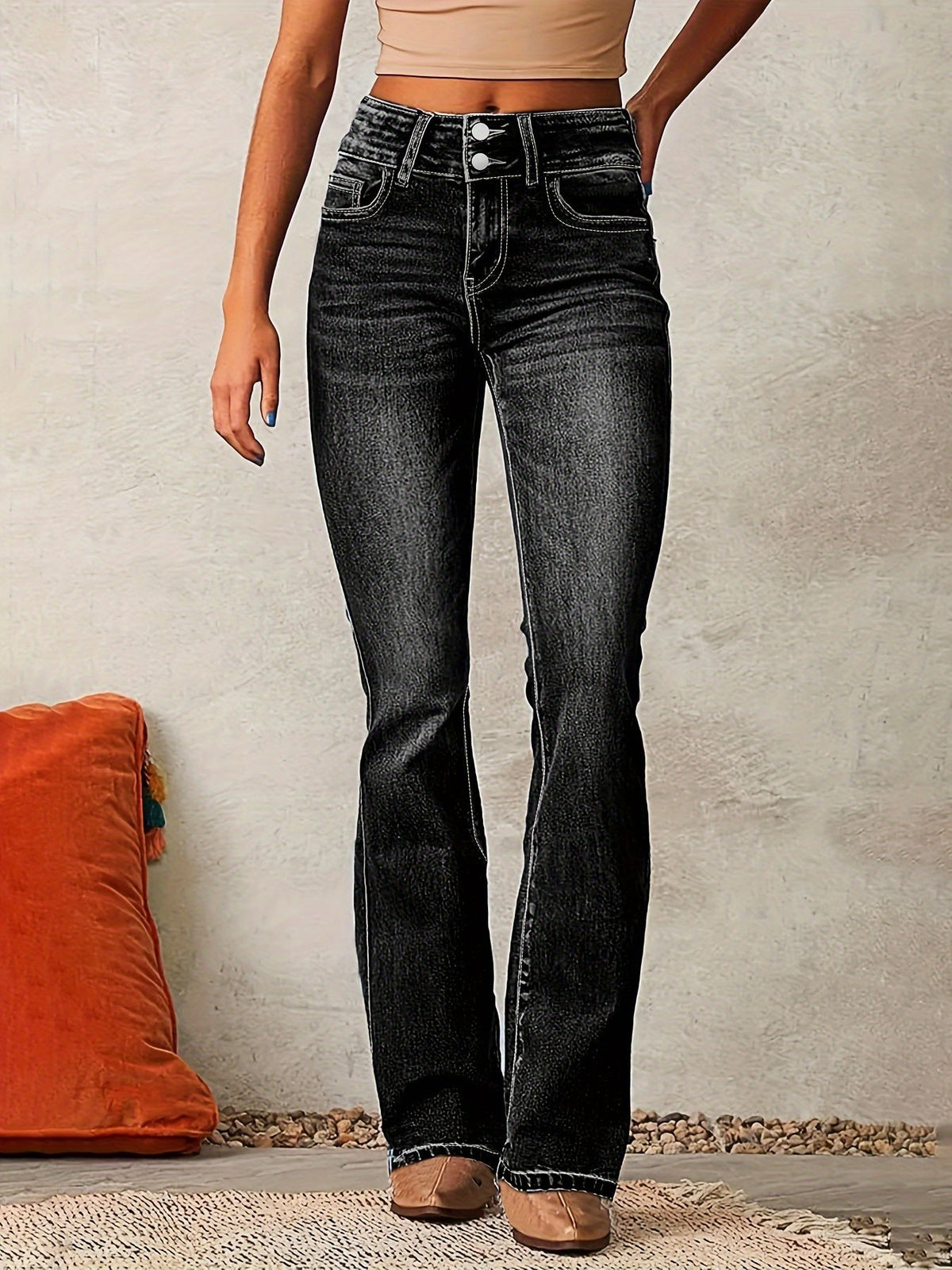 Damen-Jeans in Schwarz, High-Waist, ausgestellter Schnitt, kombiniert mit beigem Top. Modetrend, lässiger Look, ideal für Freizeit und Alltag.