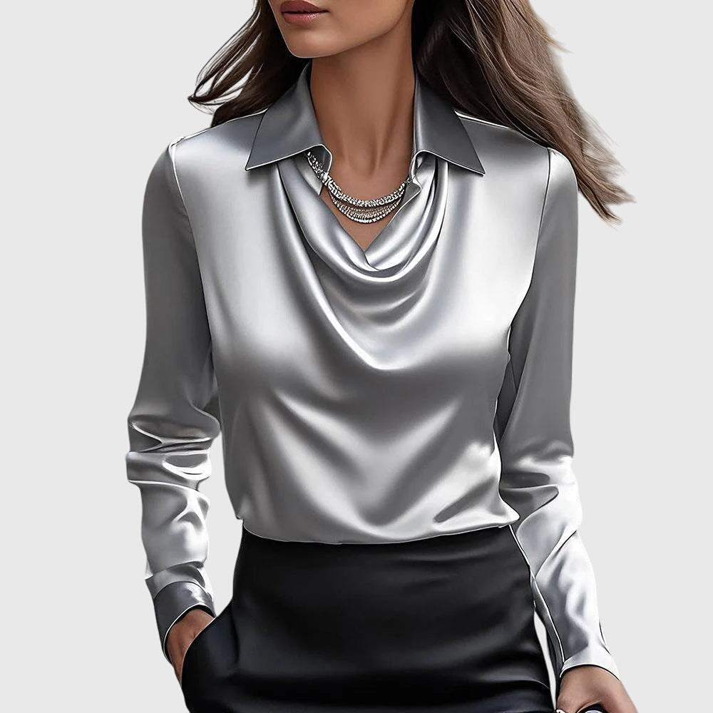 Elegante Frau in silberner Satinbluse mit Wasserfallausschnitt und schwarzem Rock, modisches Outfit, stilvolle Damenmode, luxuriöses Design.