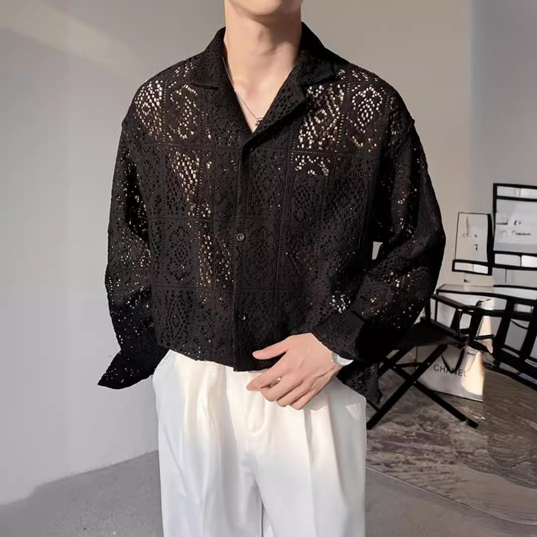 Mann trägt schwarze, durchbrochene Spitzenbluse und weiße Hose. Modetrend, elegante Herrenmode, stilvolles Outfit, moderne Kleidung.