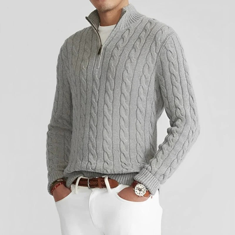 Grauer Zopfmuster-Pullover mit Reißverschluss, getragen von einem Mann in weißem Hemd und Hose. Modischer Herrenpullover, eleganter Freizeitlook.