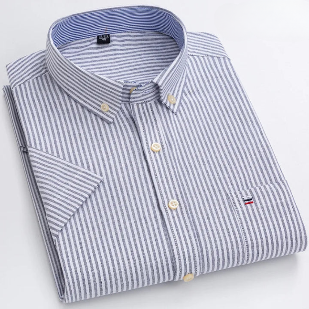 Gestreiftes Herrenhemd mit Button-Down-Kragen, gefaltet. Blau-weiße Streifen, Brusttasche mit Logo. Elegantes Design, hochwertige Baumwolle.