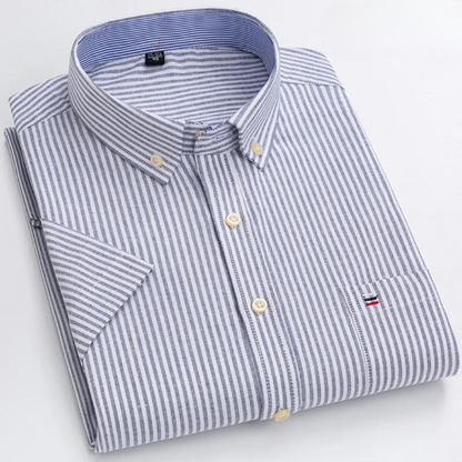 Gestreiftes Herrenhemd mit Button-Down-Kragen, gefaltet. Blau-weiße Streifen, Brusttasche mit Logo. Elegantes Design, hochwertige Baumwolle.