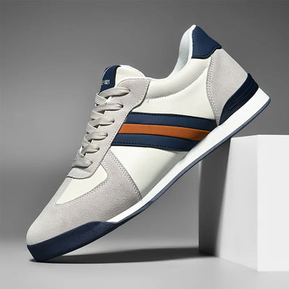 Herren-Sneaker in Weiß und Blau mit braunen Streifen, sportliches Design, auf weißem Podest, ideal für Freizeit und Sport.