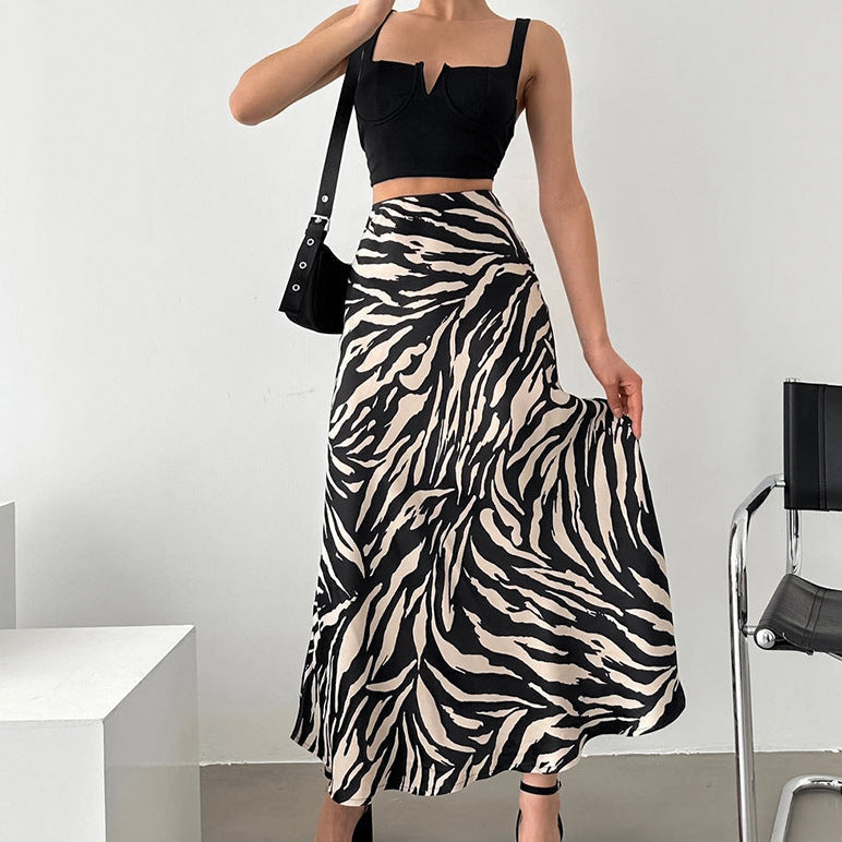 Frau in schwarzem Crop-Top und Zebra-Muster-Rock, modisch, trendig, Sommermode, stehend in modernem Raum, stilvolle Kleidung, Modefotografie.