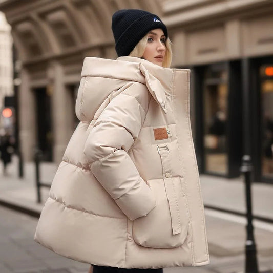 Frau in beiger Daunenjacke und schwarzer Mütze auf städtischer Straße. Wintermode, warme Kleidung, stilvolle Damenjacke, Outdoor-Bekleidung.