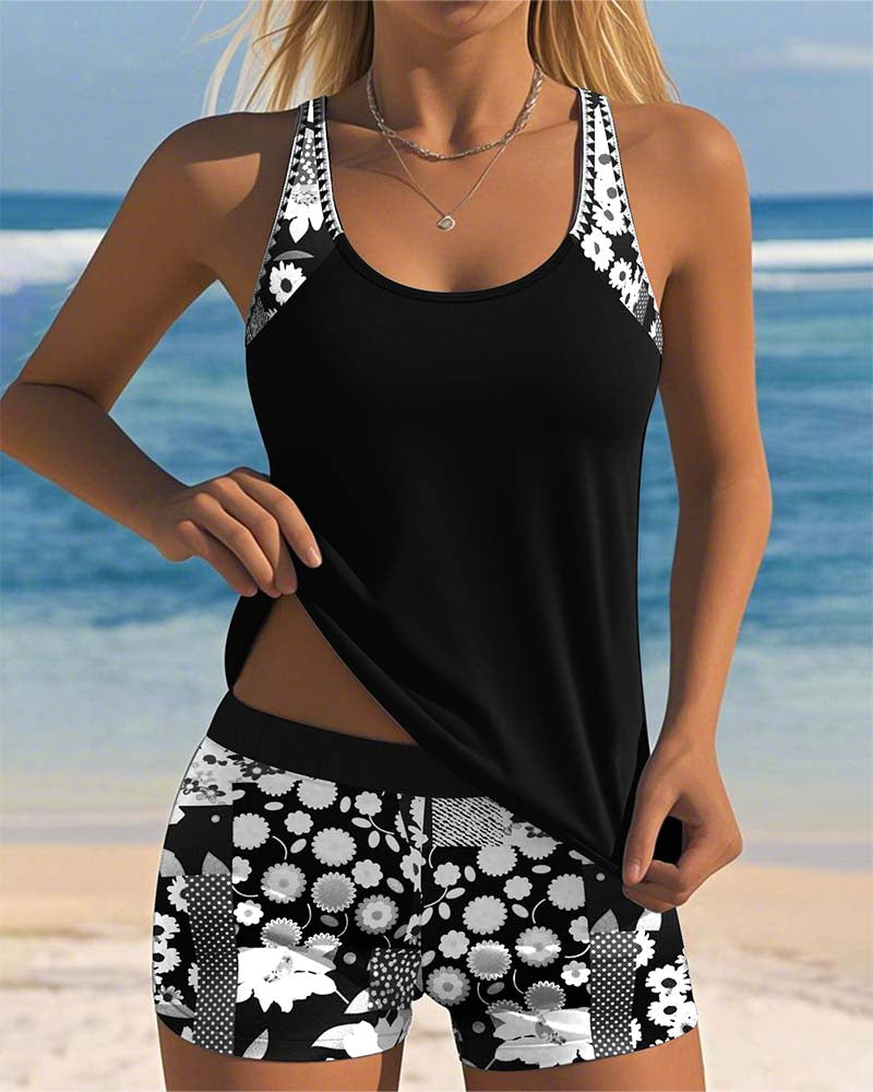 Frau in schwarz-weißem Sportoutfit mit Blumenmuster am Strand, Sommermode, Sportbekleidung, Tanktop und Shorts, Strandhintergrund.