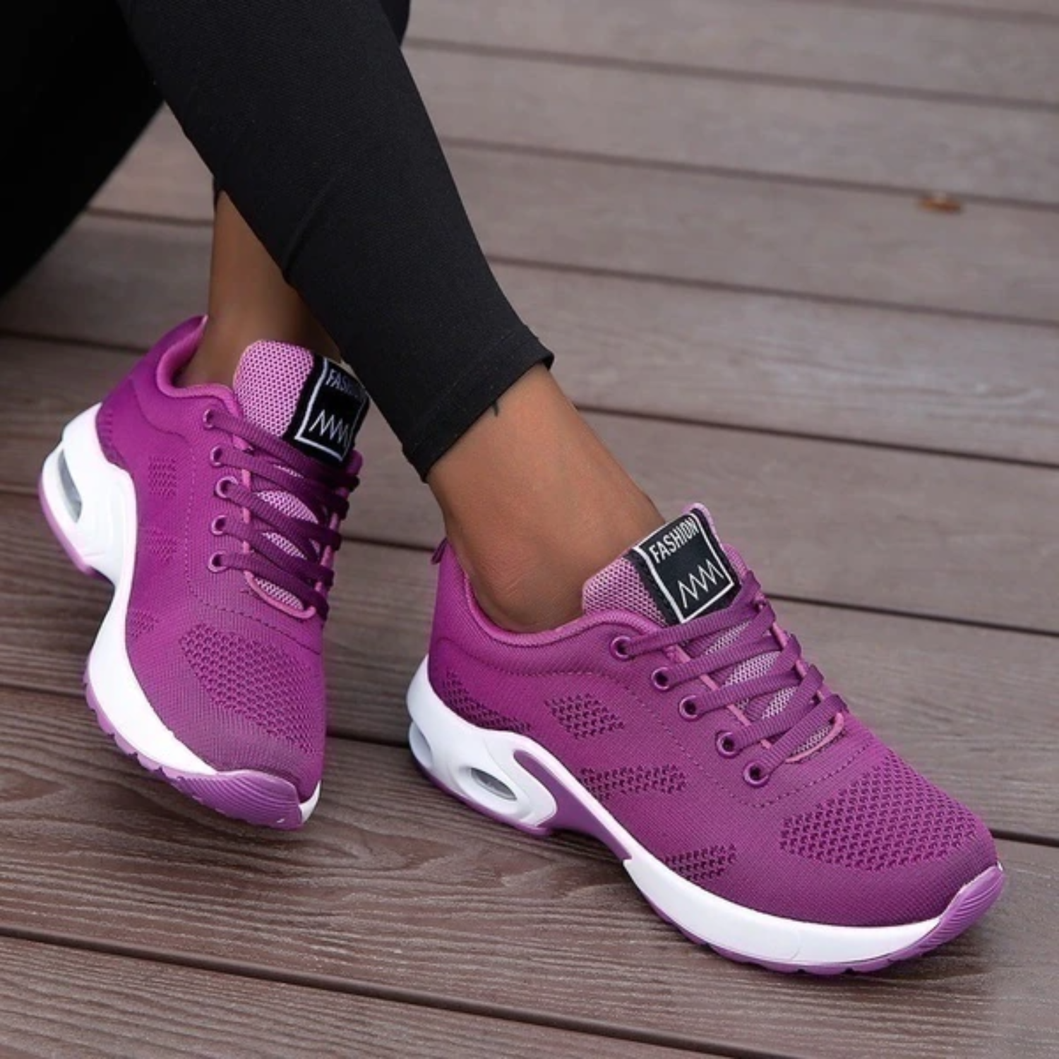Lila Damen-Sneaker auf Holzterrasse, sportlich und modern, ideal für Freizeit und Fitness. Bequeme Turnschuhe mit weißer Sohle und atmungsaktivem Material.