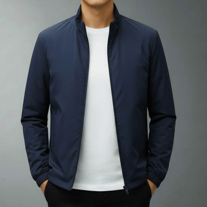 Dunkelblaue Herrenjacke mit Reißverschluss, getragen über weißem T-Shirt. Modische, lässige Herrenbekleidung für Herbst und Frühling.
