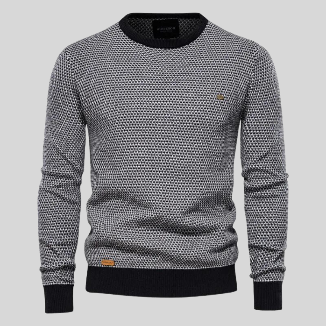 Grauer Herrenpullover mit Rundhalsausschnitt, schwarzem Rippstrick an Bündchen und Saum, geometrischem Muster. Modischer Strickpullover für Männer.