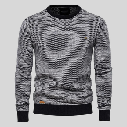 Grauer Herrenpullover mit Rundhalsausschnitt, schwarzem Rippstrick an Bündchen und Saum, geometrischem Muster. Modischer Strickpullover für Männer.