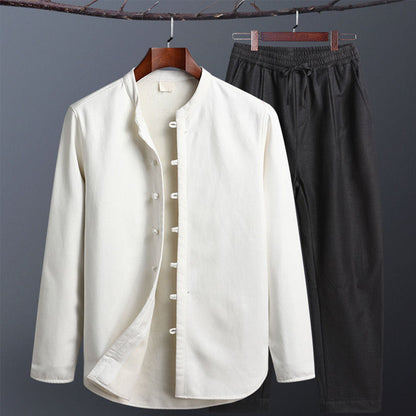 Weiße Herren-Hemdjacke mit Stehkragen und schwarzen Freizeithosen auf einem Kleiderbügel. Modische Herrenbekleidung, elegant und lässig.