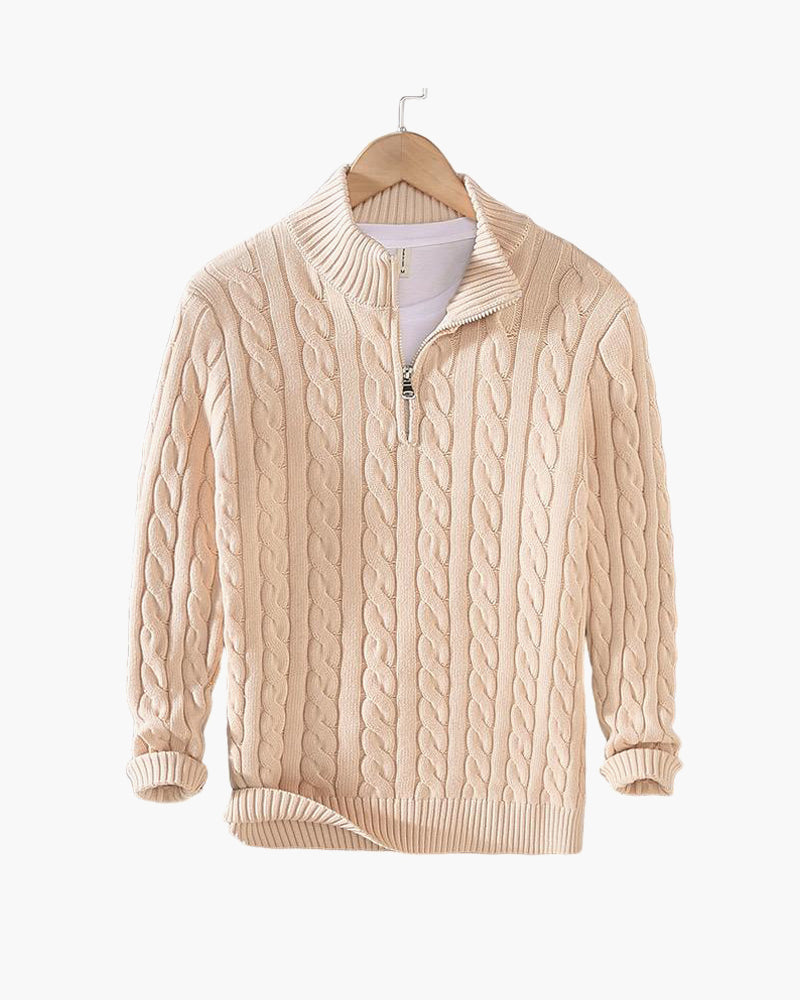 Beiger Zopfmuster-Pullover mit Reißverschluss, hängend auf Holzkleiderbügel. Modischer Strickpullover für Herren, ideal für Herbst und Winter.