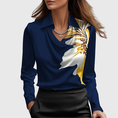 Frau in dunkelblauer Bluse mit großem Blumenmuster, eleganter Halskette und schwarzem Rock. Modetrend, Damenmode, stilvolle Kleidung.