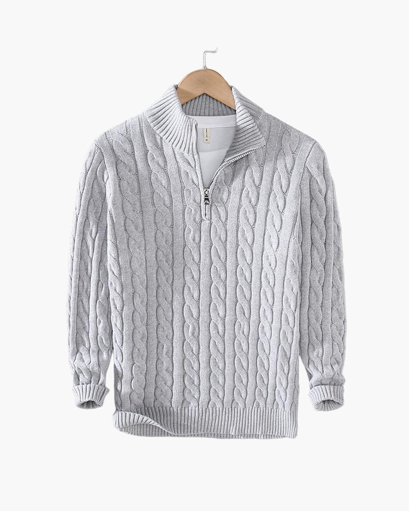 Grauer Zopfmuster-Pullover mit Reißverschluss und Stehkragen auf Holzkleiderbügel. Strickmode, Herrenbekleidung, Winterpullover.