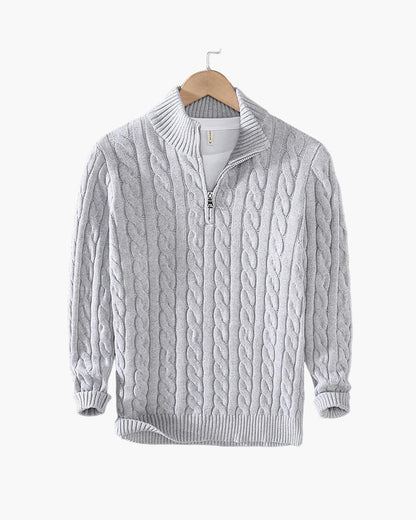 Grauer Zopfmuster-Pullover mit Reißverschluss und Stehkragen auf Holzkleiderbügel. Strickmode, Herrenbekleidung, Winterpullover.