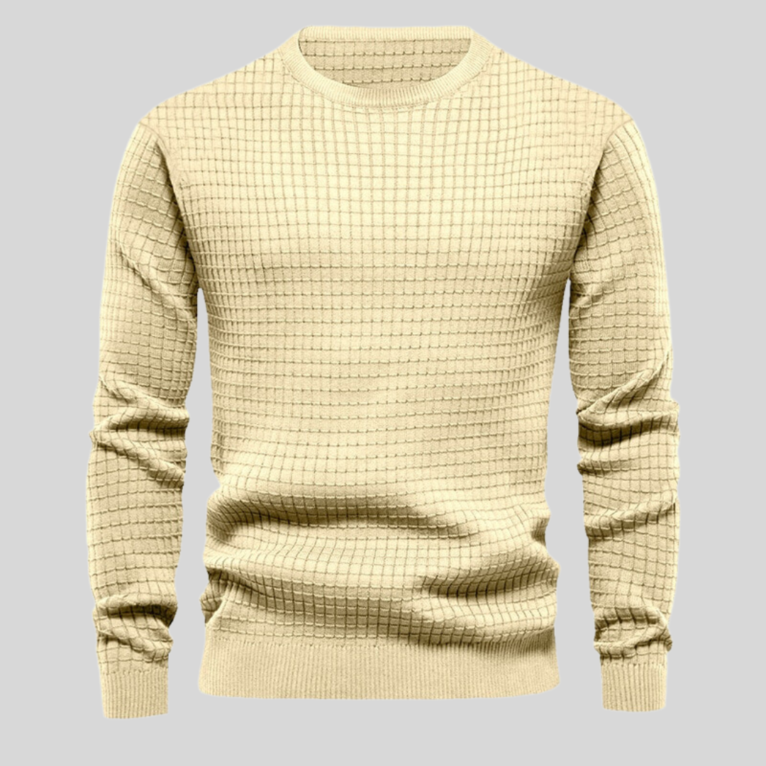 Beiger Strickpullover mit Karomuster auf grauem Hintergrund. Modischer Herrenpullover, warm und stilvoll. Ideal für Herbst- und Wintermode.