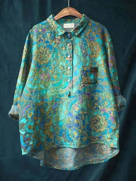 Bunte Damenbluse mit floralen Mustern, blau-goldene Farben, Langarm, Knopfleiste, elegantes Design, ideal für modische Outfits.