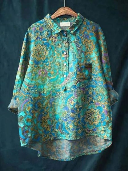Bunte Damenbluse mit floralen Mustern, blau-goldene Farben, Langarm, Knopfleiste, elegantes Design, ideal für modische Outfits.