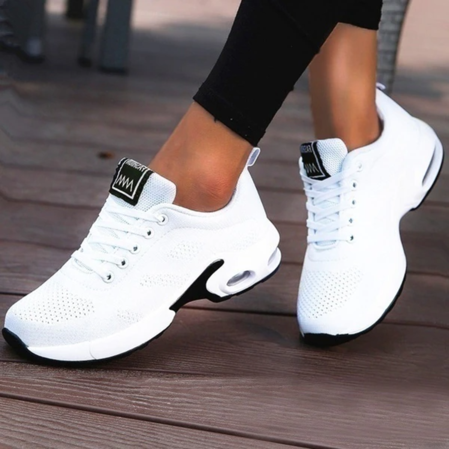 Weiße Damen-Sneaker mit Luftpolstersohle auf Holzterrasse, sportlich und modern, ideal für Fitness und Freizeit. Bequeme Sportschuhe für Damen.