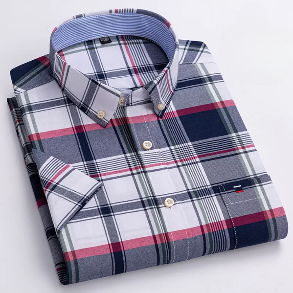 Gestreiftes Herrenhemd mit Karomuster, kurzärmelig, in Blau, Rot und Weiß, gefaltet auf weißem Hintergrund. Elegante Freizeitmode.