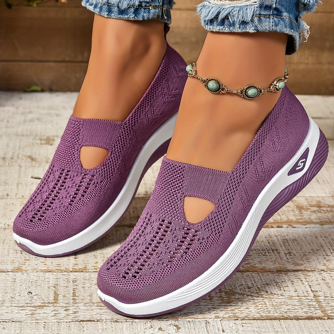 Lila Damen-Sneaker mit Strickmuster, weißer Sohle und Schmuckknöchelband auf Holzfußboden. Bequeme, modische Freizeitschuhe.
