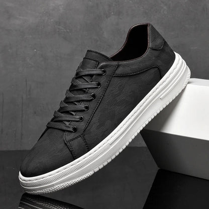 Schwarzer Sneaker mit weißer Sohle, seitlich aufgestellt vor grauem Hintergrund. Moderner Herrenschuh, ideal für Freizeit und Alltag.