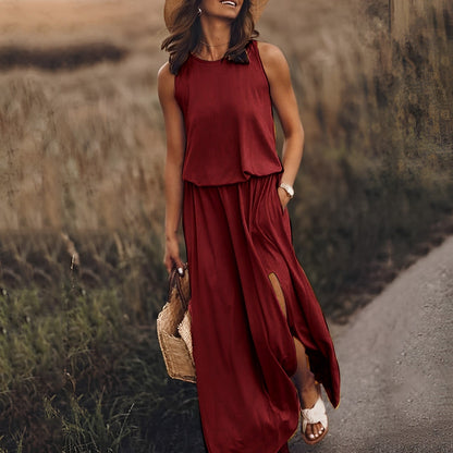Frau in rotem Maxikleid mit Schlitz, Strohhut und Korbtasche spaziert auf ländlichem Weg. Sommermode, eleganter Freizeitlook, Naturkulisse.