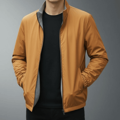 Braune Herrenjacke mit Reißverschluss, schwarzem Innenfutter und Stehkragen, getragen von einer Person. Modische Herbstjacke für Männer.