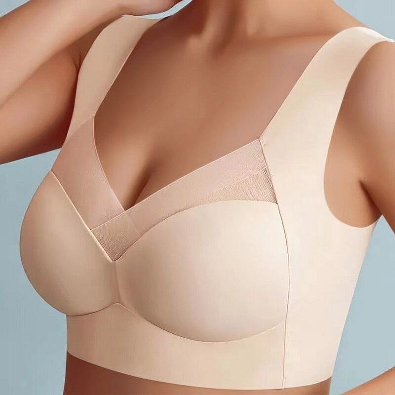 Frau trägt nahtlosen, hautfarbenen BH mit breiten Trägern und V-Ausschnitt. Bequeme Damenunterwäsche, ideal für Alltag und Sport.