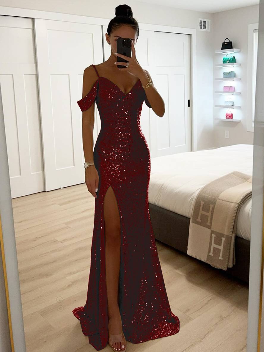 Frau im eleganten, roten Paillettenkleid mit Schlitz, steht in modernem Schlafzimmer. Abendmode, glamouröses Design, modisches Outfit.