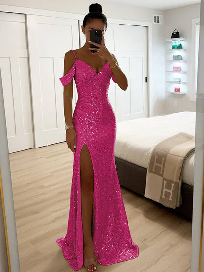 Frau in pinkem, glitzerndem Abendkleid mit hohem Beinschlitz, steht in modernem Schlafzimmer vor einem Spiegel. Elegante Abendmode, glamouröses Design.