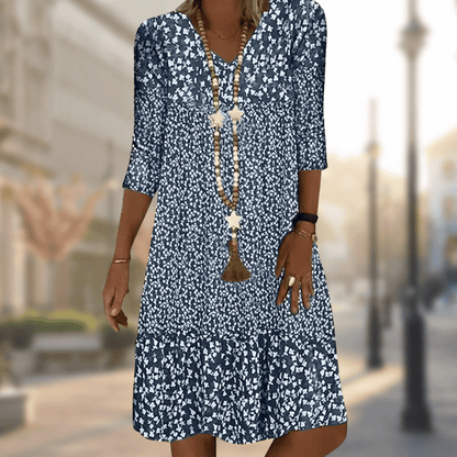 Dame in geblümtem Sommerkleid auf städtischer Straße. Modetrend 2023, lässiger Stil, blau-weißes Muster, elegantes Design, Freizeitmode.
