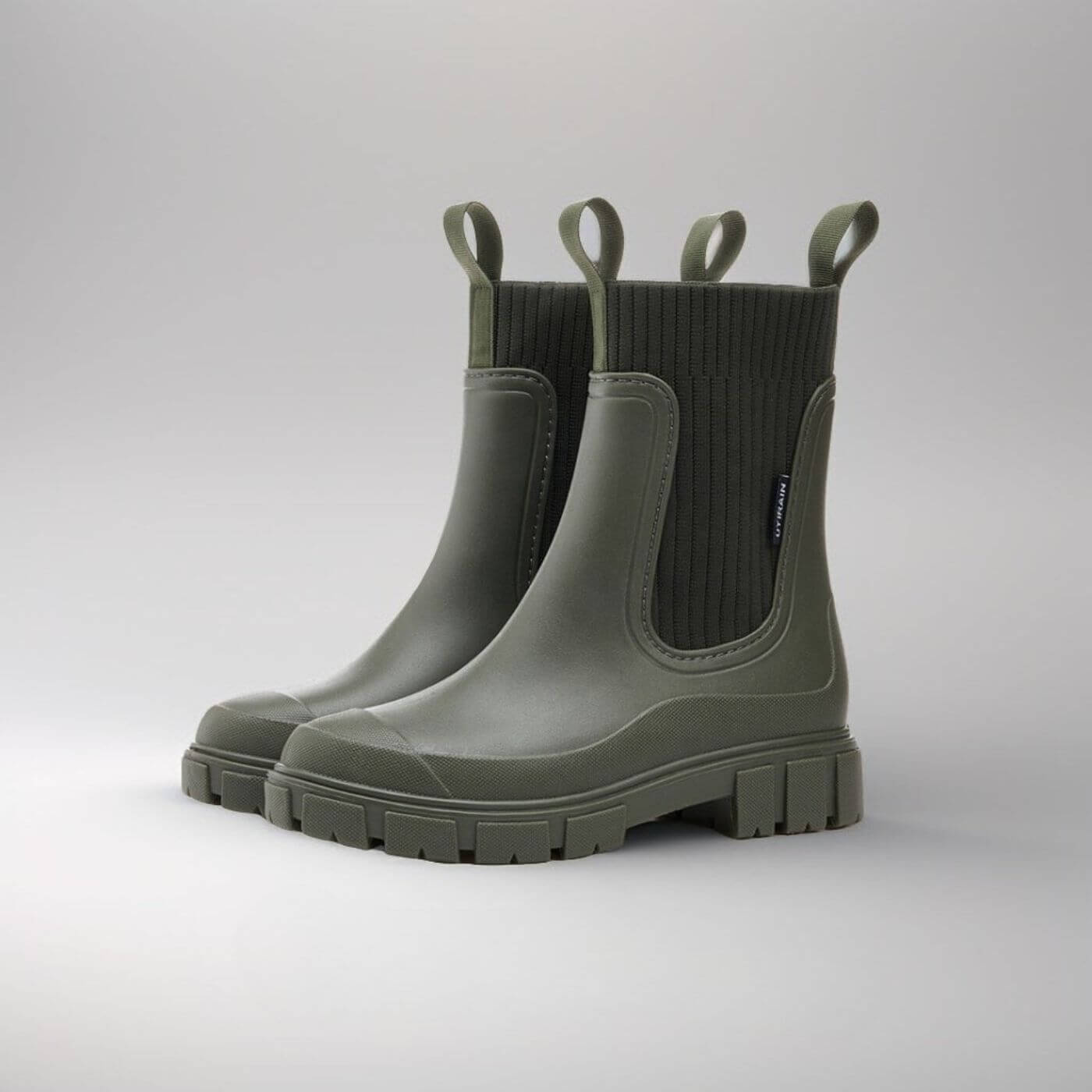 Grüne Gummistiefel mit dicker Sohle, seitlichen Schlaufen und geripptem Schaft. Perfekt für Regenwetter und Outdoor-Aktivitäten.