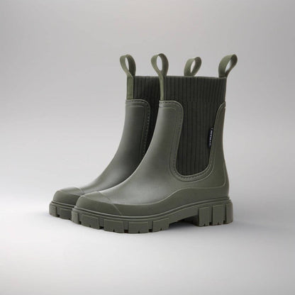Grüne Gummistiefel mit dicker Sohle, seitlichen Schlaufen und geripptem Schaft. Perfekt für Regenwetter und Outdoor-Aktivitäten.