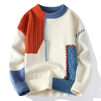 Bunter Strickpullover mit geometrischem Patchwork-Design in Rot, Blau und Creme. Modischer, warmer Pullover für Herbst und Winter.