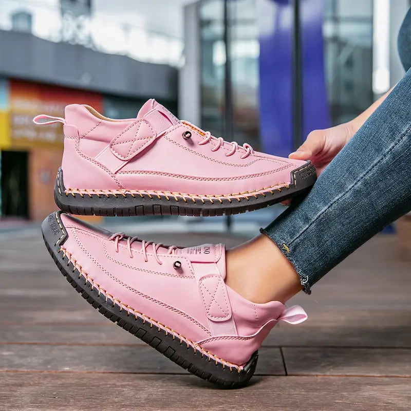 Rosa Damen-Sneaker mit schwarzer Sohle, getragen von einer Person in Jeans. Modische Straßenschuhe, ideal für Freizeit und urbanen Stil.