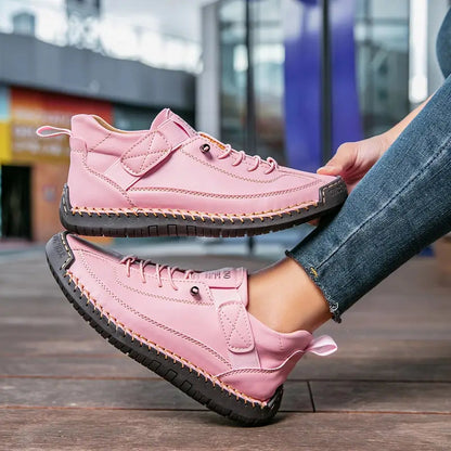 Rosa Damen-Sneaker mit schwarzer Sohle, getragen von einer Person in Jeans. Modische Straßenschuhe, ideal für Freizeit und urbanen Stil.