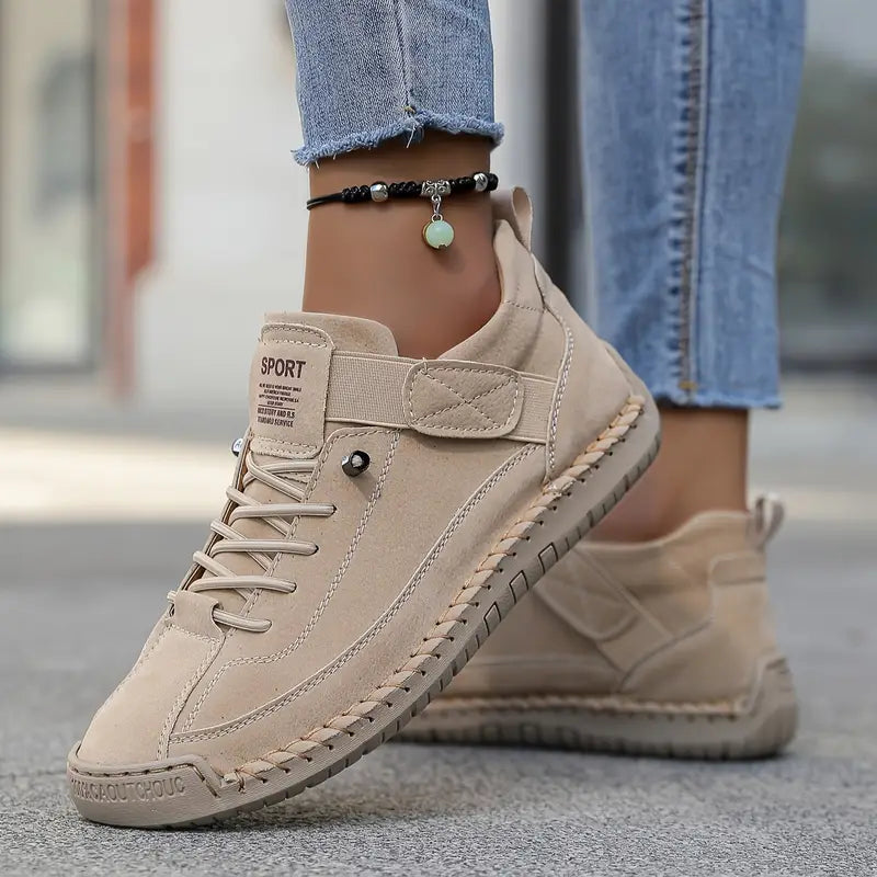 Beige Sneaker aus Wildleder mit Schnürung, getragen von Person in blauen Jeans. Modischer Freizeitschuh, ideal für urbanen Stil und Komfort.