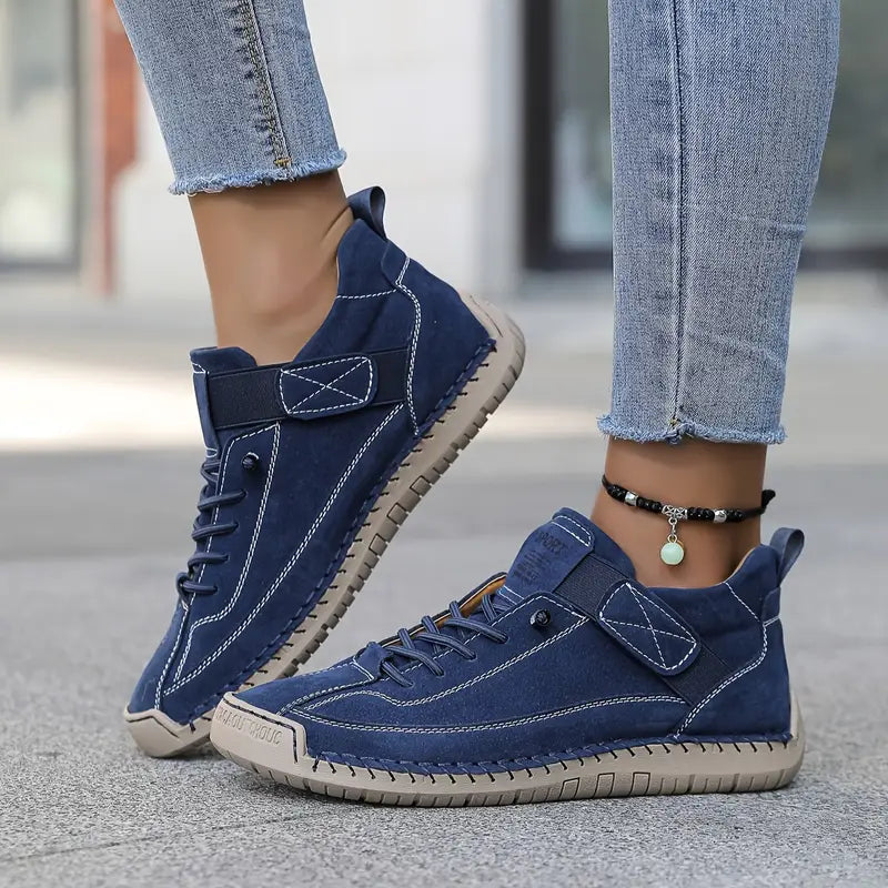 Blaue Freizeitschuhe für Damen, kombiniert mit hellblauen Jeans. Modische Sneaker mit weißer Naht und beiger Sohle, ideal für den urbanen Look.