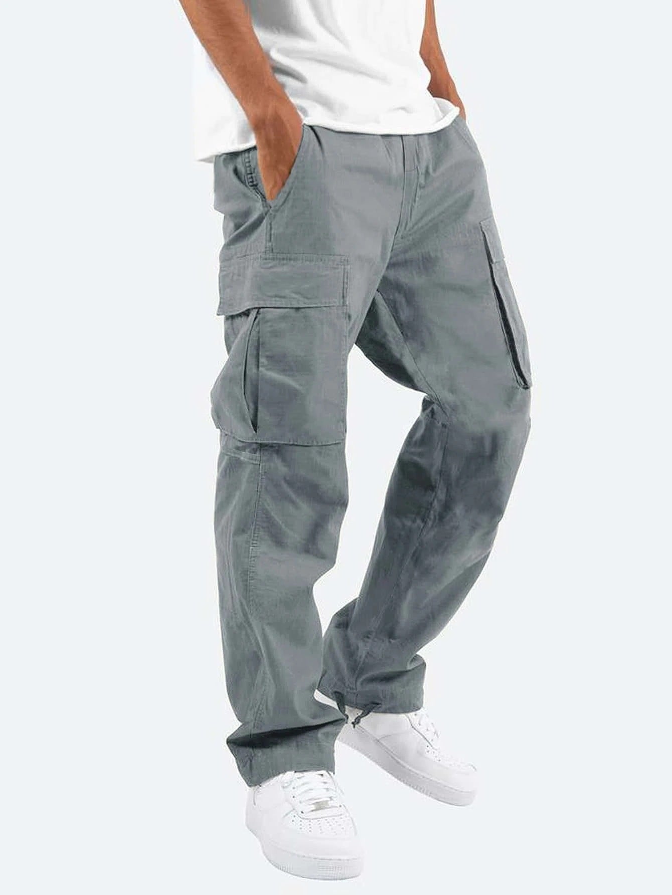 Graue Cargo-Hose für Herren, lässiger Stil, mit Seitentaschen, kombiniert mit weißen Sneakers und weißem T-Shirt. Ideal für Freizeitmode.