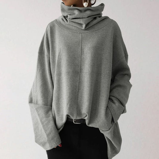 Grauer Oversize-Pullover mit Rollkragen, lässig geschnitten, aus weichem Material. Perfekt für Herbstmode und gemütliche Outfits.