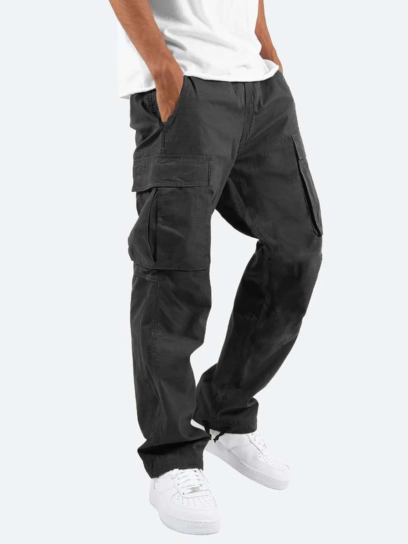 Schwarze Cargo-Hose für Herren, lässig geschnitten, mit großen Seitentaschen, kombiniert mit weißen Sneakers und weißem T-Shirt.