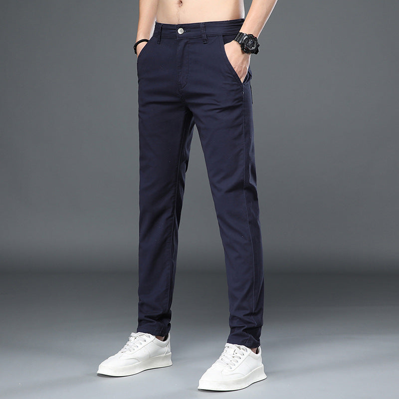 Dunkelblaue Herren-Chinohose, modern geschnitten, kombiniert mit weißen Sneakers. Perfekt für Freizeit und Büro. Eleganter, zeitloser Stil.