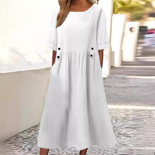 Frau in weißem Sommerkleid mit Taschen, knielang, auf gepflastertem Weg. Elegantes Design, ideal für warme Tage. Mode, Damenbekleidung, Sommerkleid.