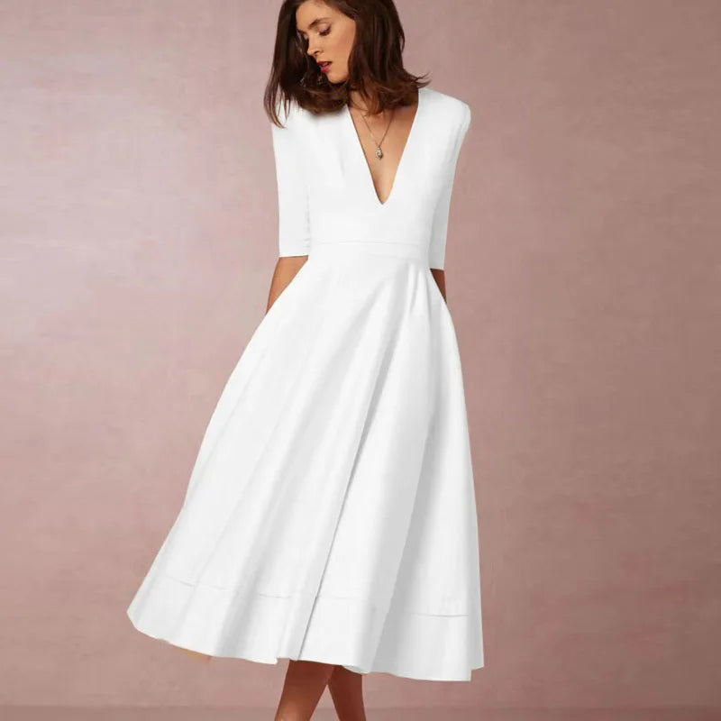 Frau in elegantem weißen Kleid mit V-Ausschnitt und halblangen Ärmeln vor rosa Hintergrund. Mode, Damenbekleidung, Abendkleid.