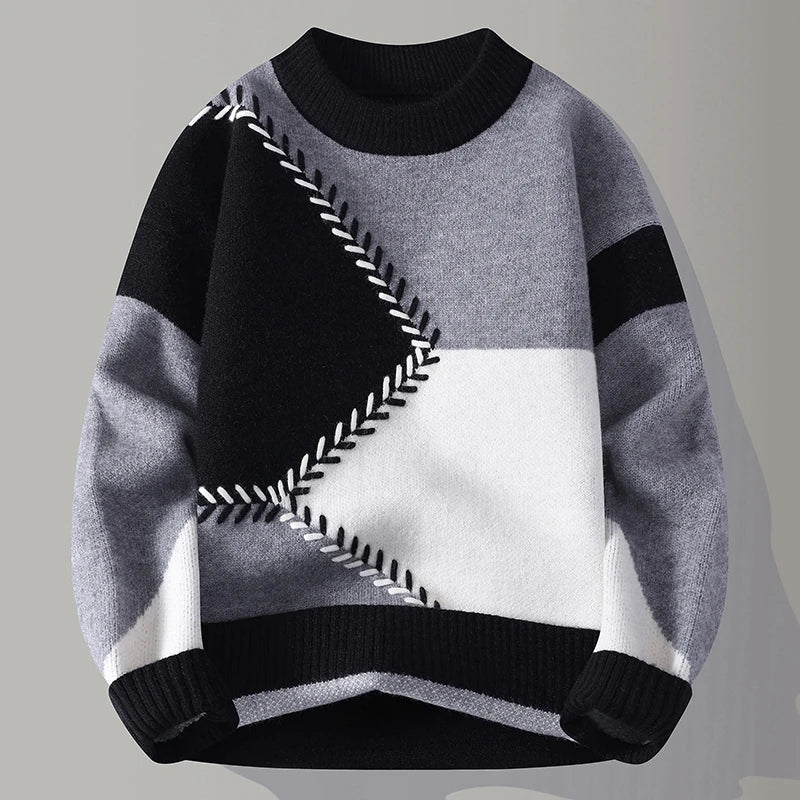 Grauer und schwarzer Patchwork-Pullover mit geometrischem Muster, Rundhalsausschnitt und langen Ärmeln. Modischer Strickpullover für Herren.