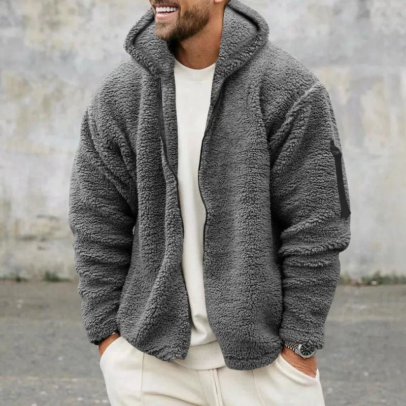 Mann trägt graue Fleecejacke mit Kapuze, lässiger Stil, Herbstmode, Outdoor-Bekleidung, warm und bequem, ideal für kühle Temperaturen.