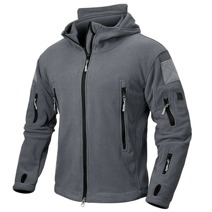 Graue Fleecejacke mit Kapuze, mehreren Reißverschlusstaschen und Daumenlöchern. Outdoor-Bekleidung, warm, funktional, ideal für Wandern und Trekking.